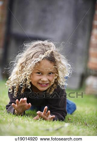Young girl crawls on grass toward camera View Large Photo Image Stock Image - Young girl crawls on grass toward camera. Fotosearch