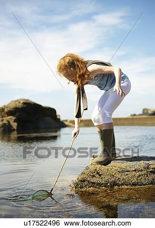 Young girl fishing in rock pool View Large Photo Image Stock Photograph - Young girl fishing in rock pool. Fotosearch