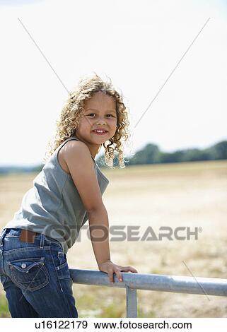 Young girl on farm gate View Large Photo Image Stock Photo - Young girl on farm gate. Fotosearch