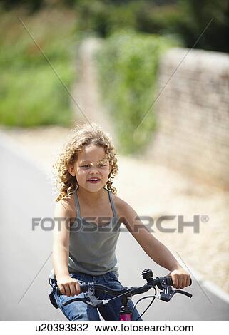 Young girl riding bicycle View Large Photo Image Stock Image - Young girl riding bicycle. Fotosearch