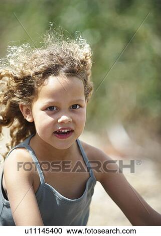 Young girl riding bicycle wind in hair View Large Photo Image Stock Image - Young girl riding bicycle wind in hair. Fotosearch