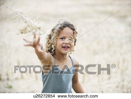 Young girl throwing wheat in field View Large Photo Image Picture - Young girl throwing wheat in field. Fotosearch