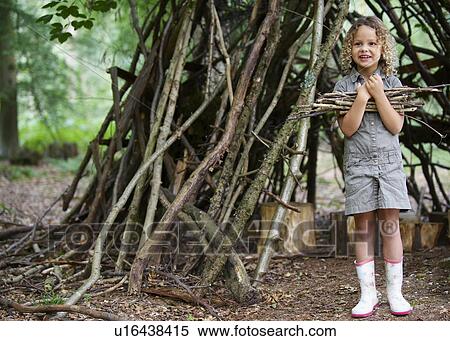 Young girl with pile of twigs in woods View Large Photo Image Stock Photography - Young girl with pile of twigs in woods. Fotosearch