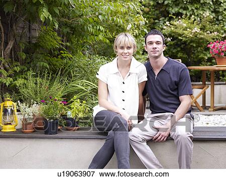 Couple sitting in garden facing camera View Large Photo Image Stock Photo - Couple sitting in garden facing camera. Fotosearch