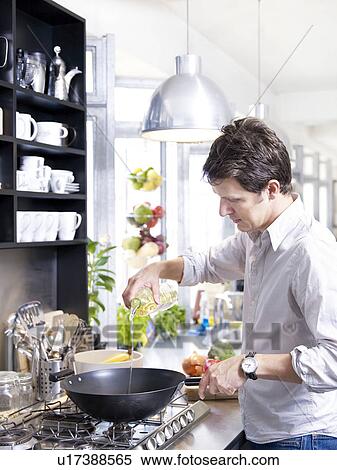 Man in kitchen cooking with wok View Large Photo Image Stock Photography - Man in kitchen cooking with wok. Fotosearch