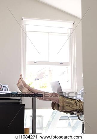 Stock Image - Man on laptop in sunny home office. Fotosearch