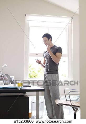 Man with headphones in home office View Large Photo Image Stock Image - Man with headphones in home office. Fotosearch
