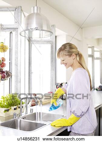 Woman in kitchen at sink cleaning View Large Photo Image Stock Image - Woman in kitchen at sink cleaning. Fotosearch