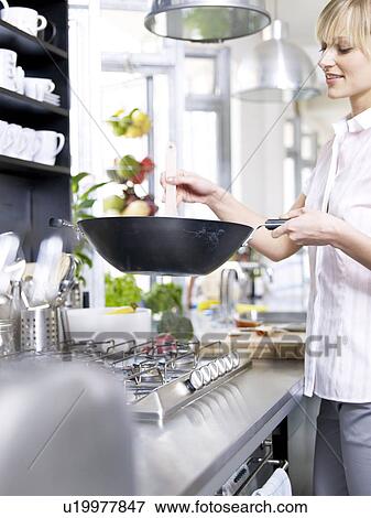 Woman in kitchen cooking with wok View Large Photo Image Stock Photo - Woman in kitchen cooking with wok. Fotosearch