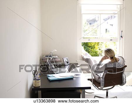 Woman sitting in sunny home office View Large Photo Image Stock Photo - Woman sitting in sunny home office. Fotosearch