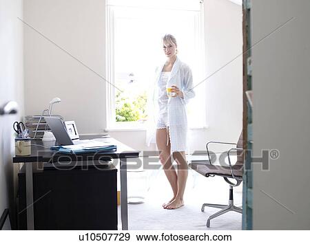 Woman standing in sunny home office View Large Photo Image Stock Photo - Woman standing in sunny home office. Fotosearch