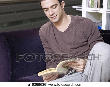 Stock Photograph - Young man sitting relaxed and reading. Fotosearch
