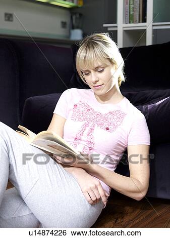 Stock Photograph - Young woman sitting relaxed and reading. Fotosearch