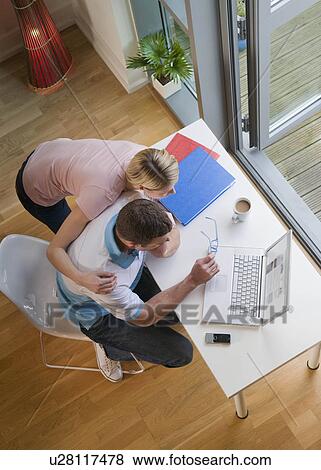 A couple looking at a laptop View Large Photo Image Stock Photo - A couple looking at a laptop. Fotosearch
