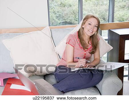 Stock Photo - A female writing notes in a file. Fotosearch