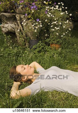 A portrait of female lying on the grass View Large Photo Image Stock Image - A portrait of female lying on the grass. Fotosearch