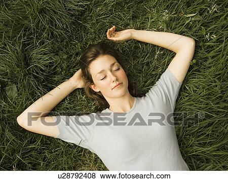 A portrait of female lying on the grass View Large Photo Image Stock Photo - A portrait of female lying on the grass. Fotosearch