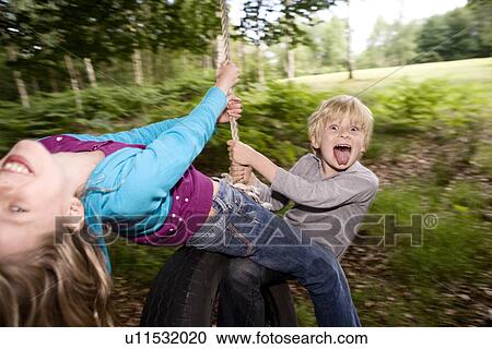 Boy and girl on tire swing View Large Photo Image Stock Image - Boy and girl on tire swing. Fotosearch