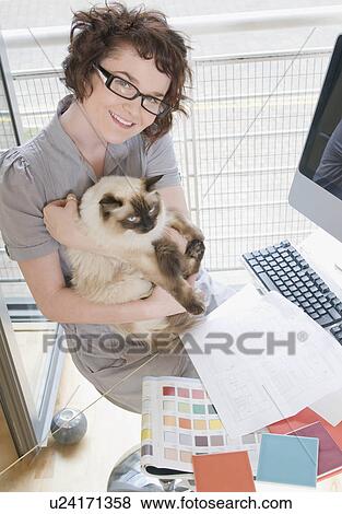 Female designer holding a cat View Large Photo Image Stock Photo - Female designer holding a cat. Fotosearch