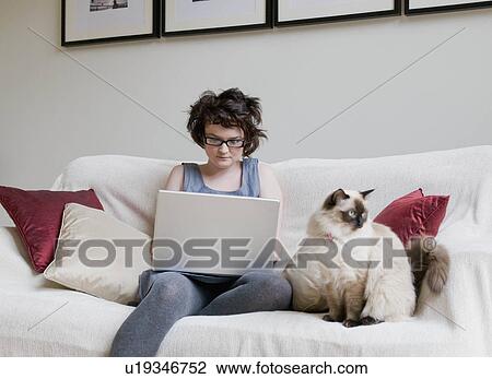 Female holding a cat and a laptop View Large Photo Image Stock Image - Female holding a cat and a laptop. Fotosearch