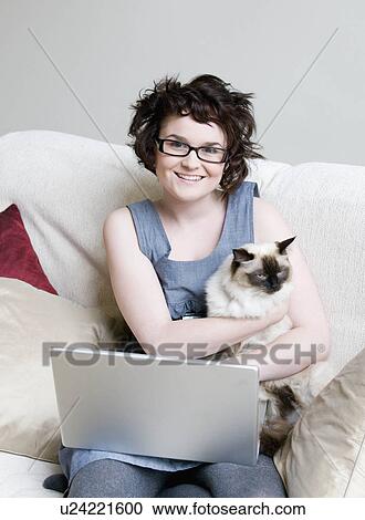Female holding a cat and a laptop View Large Photo Image Stock Image - Female holding a cat and a laptop. Fotosearch