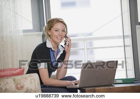Female using her laptop and phone View Large Photo Image Stock Photo - Female using her laptop and phone. Fotosearch