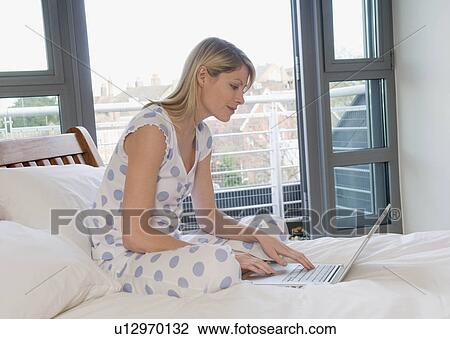 Female working from home in bed View Large Photo Image Stock Image - Female working from home in bed. Fotosearch