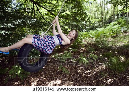 Girl swinging on tire View Large Photo Image Stock Photography - Girl swinging on tire. Fotosearch