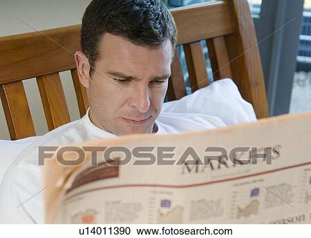 Man reads financial paper in bed View Large Photo Image Stock Image - Man reads financial paper in bed. Fotosearch