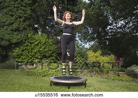 Mature woman jumping on trampoline View Large Photo Image Stock Photograph - Mature woman jumping on trampoline. Fotosearch