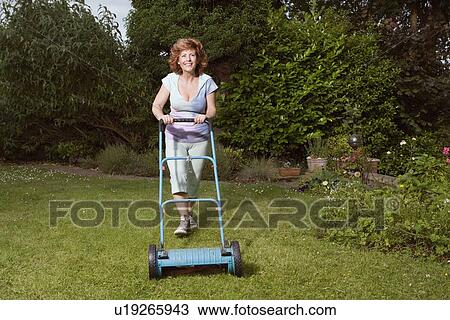 Mature woman mowing lawn View Large Photo Image Stock Image - Mature woman mowing lawn. Fotosearch