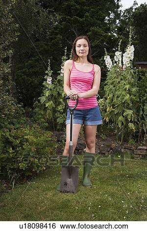 Woman holding spade in garden View Large Photo Image Stock Photograph - Woman holding spade in garden. Fotosearch