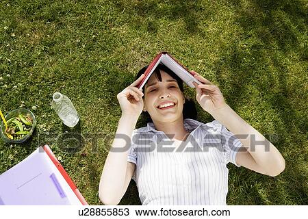 Woman shielding face with book View Large Photo Image Stock Image - Woman shielding face with book. Fotosearch