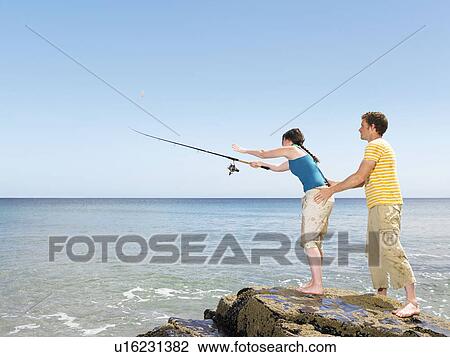 Couple fishing off rocks View Large Photo Image Stock Image - Couple fishing off rocks. Fotosearch