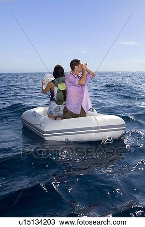 Stock Image - Couple lost at sea on little boat. Fotosearch