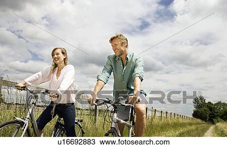 Stock Image - Couple on cycles. Fotosearch