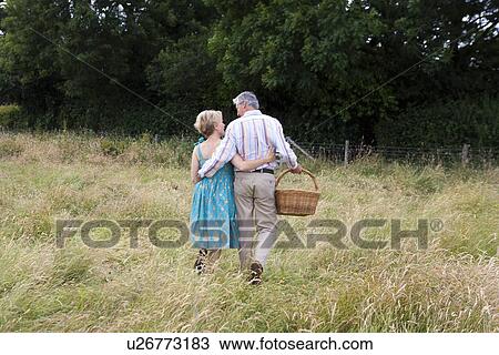 Couple waking towards gate in a field View Large Photo Image Stock Image - Couple waking towards gate in a field. Fotosearch