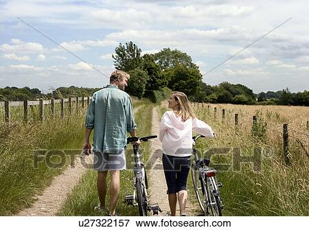 Couple walking with cycles View Large Photo Image Stock Photo - Couple walking with cycles . Fotosearch