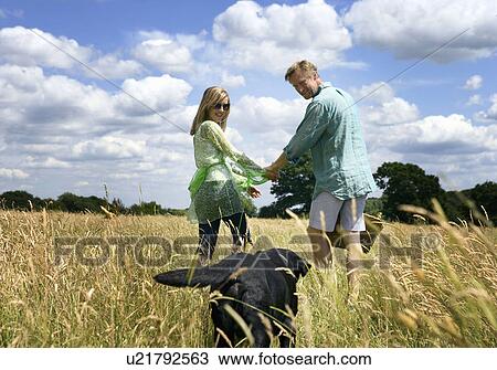 Couple with dog in field View Large Photo Image Stock Image - Couple with dog in field. Fotosearch
