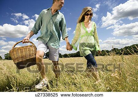 Couple with picnic basket in field View Large Photo Image Stock Photography - Couple with picnic basket in field. Fotosearch