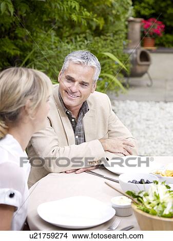 Picture - Man and woman sitting outside in garden. Fotosearch