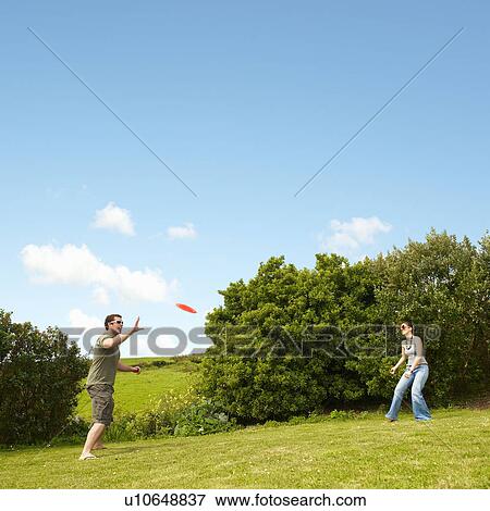 Couple playing frisbee View Large Photo Image Stock Photo - Couple playing frisbee. Fotosearch