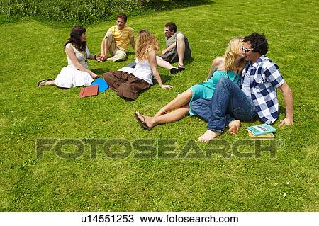 Group of young people sitting on lawn View Large Photo Image Stock Image - Group of young people sitting on lawn. Fotosearch