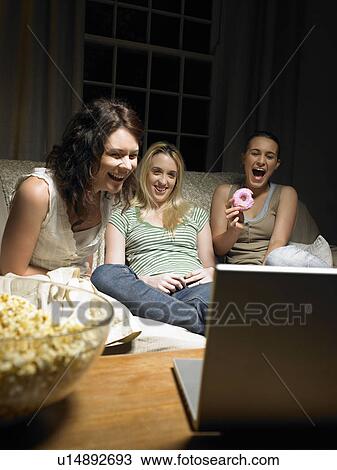 Three young women watching a movie View Large Photo Image Stock Image - Three young women watching a movie. Fotosearch
