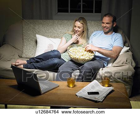 Young couple watching a movie View Large Photo Image Picture - Young couple watching a movie. Fotosearch