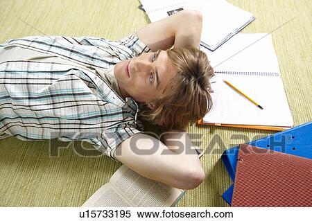 Young man lying on rug View Large Photo Image Stock Photography - Young man lying on rug. Fotosearch