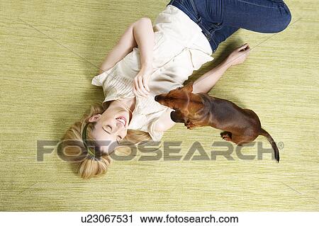 Young woman playing with dog View Large Photo Image Stock Image - Young woman playing with dog. Fotosearch