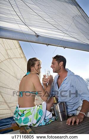 Couple drinking champagne on sailboat View Large Photo Image Stock Photography - Couple drinking champagne on sailboat. Fotosearch