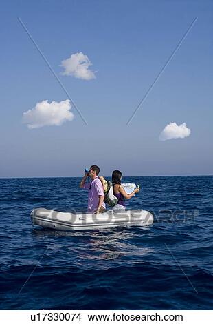 Picture - Couple lost at sea on little boat. Fotosearch