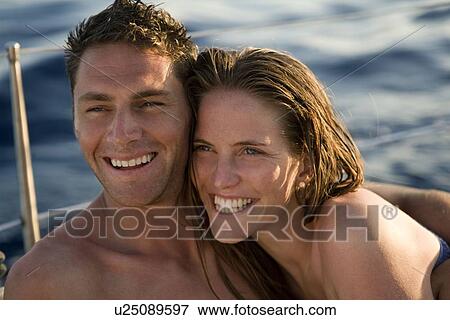 Stock Photo - Couple smiling on boat at sea. Fotosearch